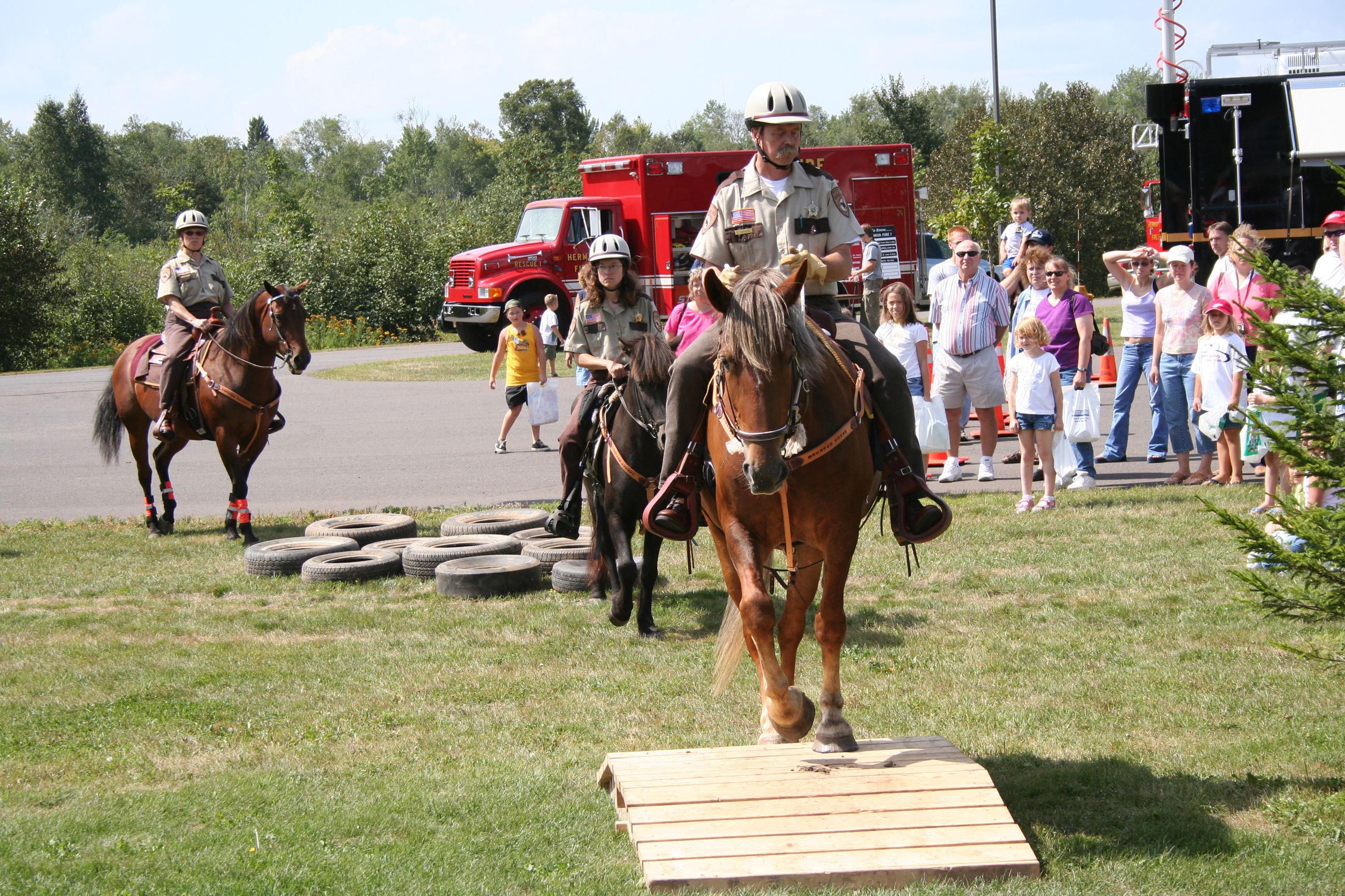 Three mounted officers performing an obstacle course