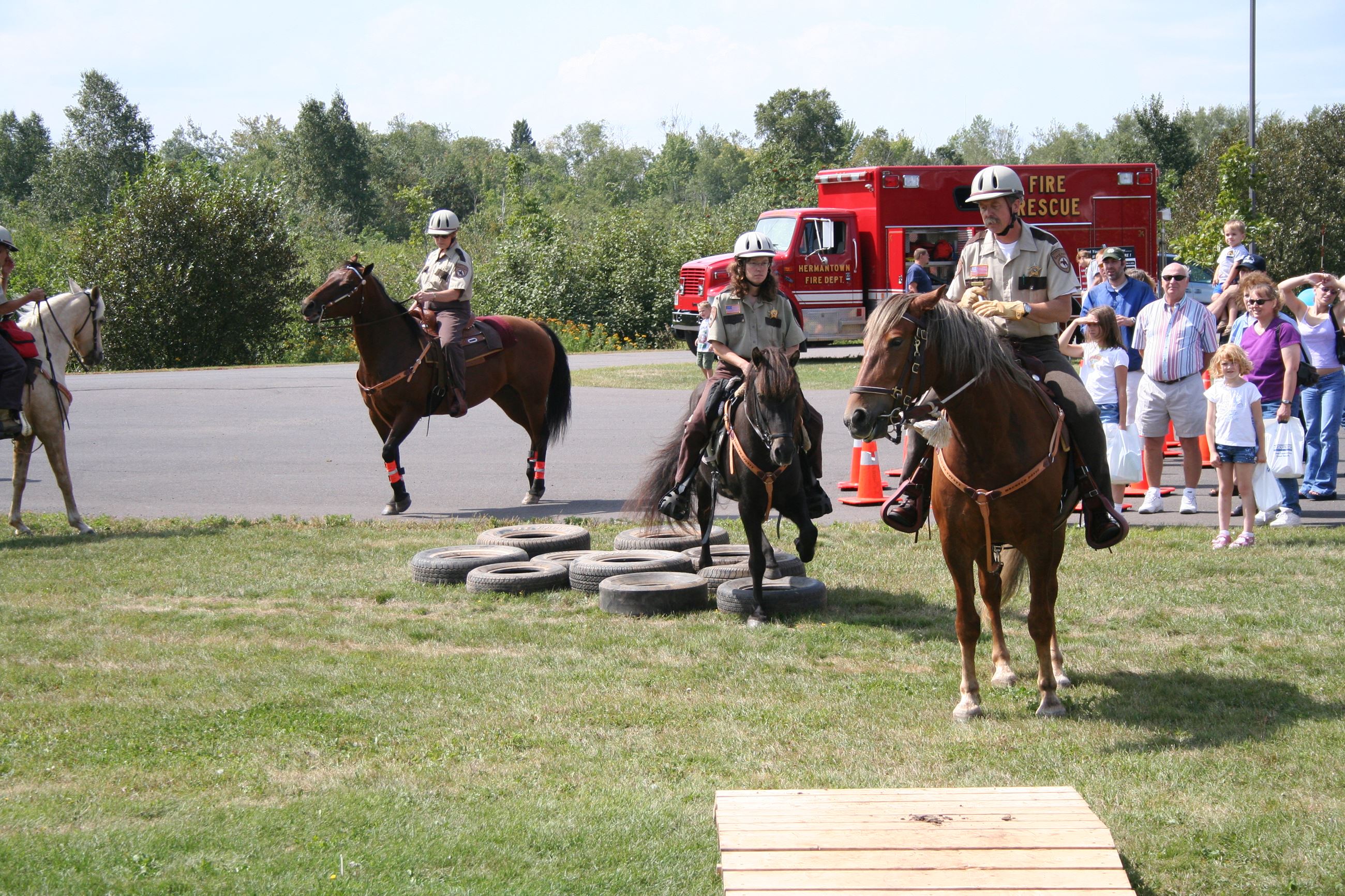 Mounted officers doing obstacle course with onlookers
